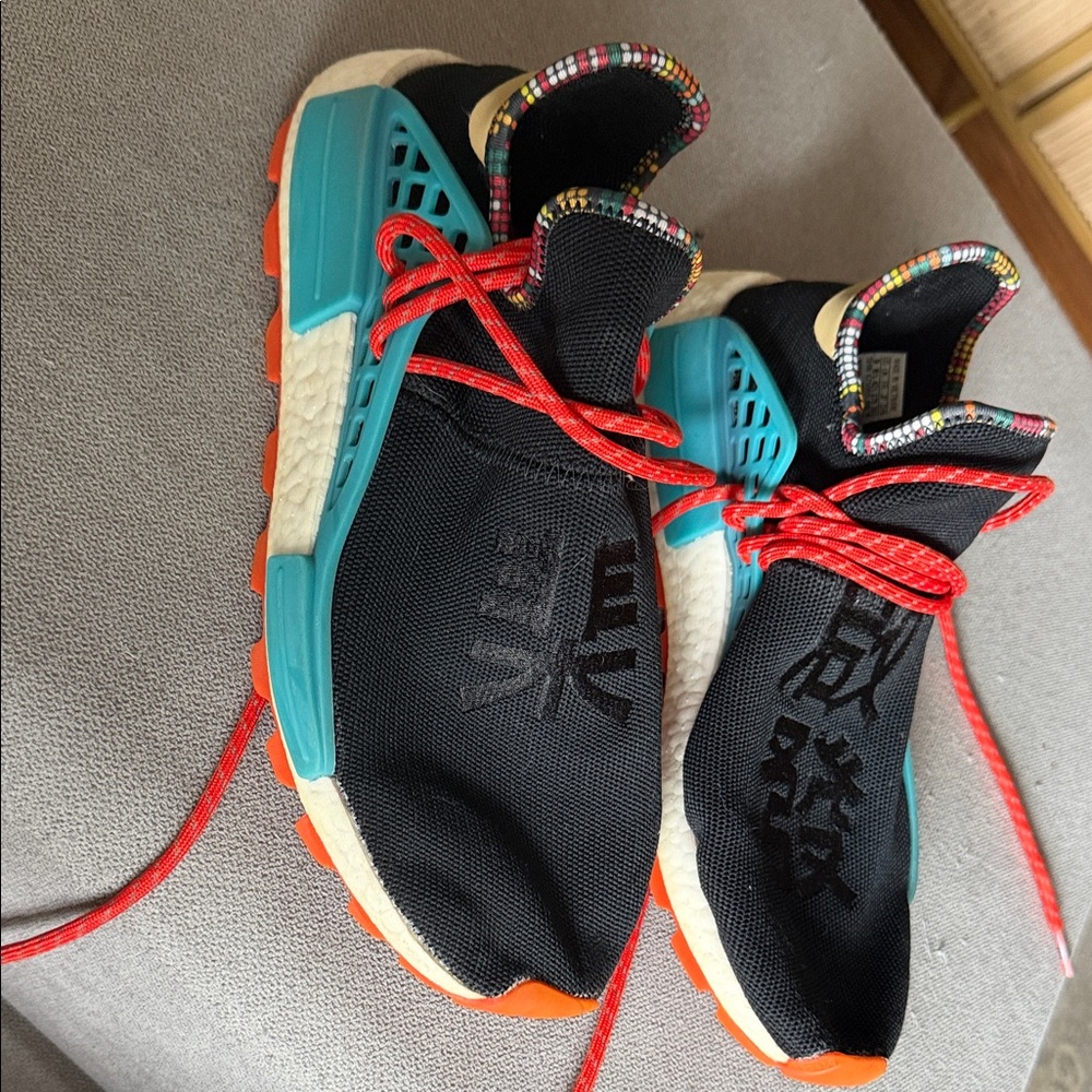 adidas Black and Teal Sneakers with Red Accents .